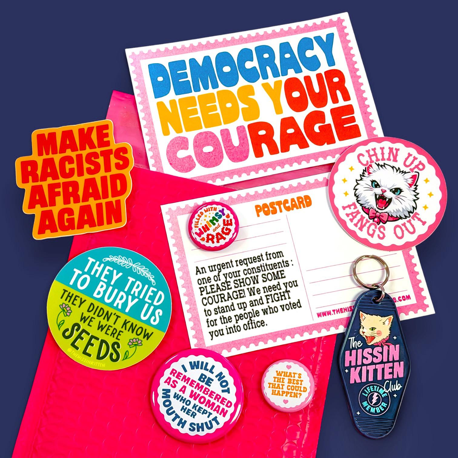 Hands packing postcards and buttons into a navy mailer